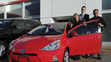 Lynda Richard poses with the 2013 Toyota Prius c she won for two years use in The Province Commuting Challenge contest. With Richard is Drew Kenney and Nazir Bharmal, right, of Regency Toyota.