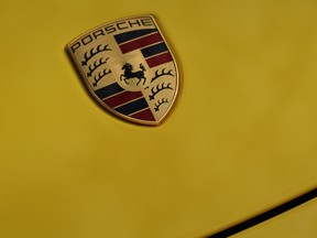 Porsche badge seen on a yellow Cayman