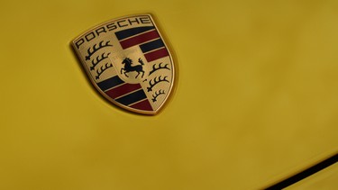 Porsche badge seen on a yellow Cayman