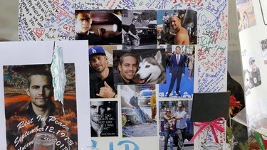 Photos and messages are seen at a roadside memorial at the site of the auto crash that took the life of actor Paul Walker and another man, in the small community of Valencia, Calif., Monday, Dec. 2, 2013. The neighborhood where "Fast & Furious" star Walker died in the one-car crash is known to attract street racers, according to law enforcement officials.