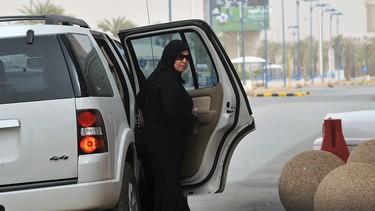 A Saudi woman gets out the backseat of a car on her way to a shopping mall in Riyadh.