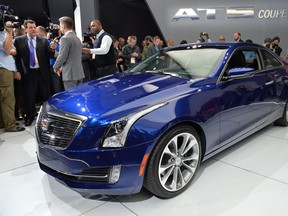 Members of the media get a look at the 2015 Cadillac ATS coupe during a press preview at the North American International Auto Show January 14, 2014 in Detroit, Michigan.
