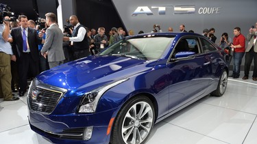 Members of the media get a look at the 2015 Cadillac ATS coupe during a press preview at the North American International Auto Show January 14, 2014 in Detroit, Michigan.