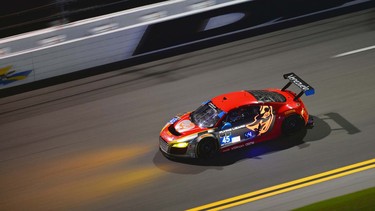 The very cool-looking Audi R8 LMS races at night with its headlights illuminating the track ahead.