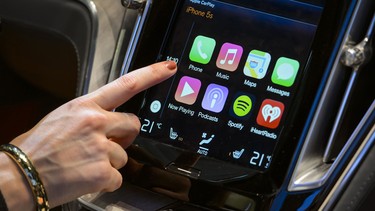 A visitor presses Apple's new CarPlay touch-screen commands inside the Volvo Estate concept car displayed during the press day of the Geneva Motor Show in Geneva, on March 4, 2014.