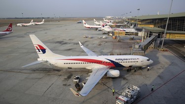 Ground staff work on a Malaysia Airlines plane at Kuala Lumpur International Airport in Sepang, Malaysia, Wednesday, March 12, 2014. The missing Malaysian jetliner may have been deliberately diverted off course, officials now believe.
