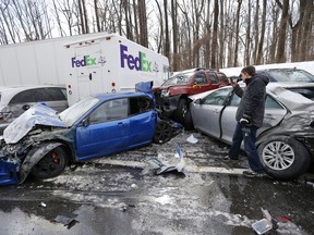 A man inspects vehicles piled up in an accident recently in Bensalem, PA.
