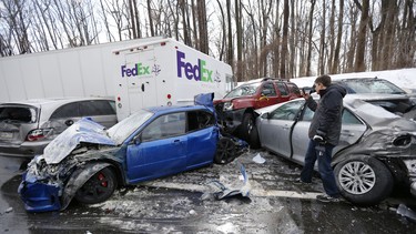 A man inspects vehicles piled up in an accident recently in Bensalem, PA.