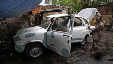 Indian workers repair an Ambassador car at a workshop in Kolkata, india, Monday, May 26, 2014. India's oldest car factory has abruptly suspended production of the hulking Ambassador sedan that has a nearly seven-decade history as the car of the Indian elite.