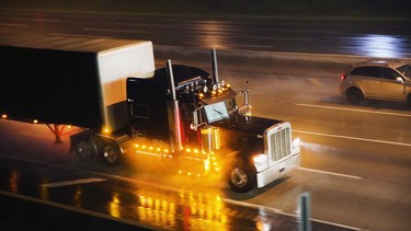 A truck driver navigates a rain-covered highway on the outskirts of Chicago. Trucking was and still is a dangerous profession.