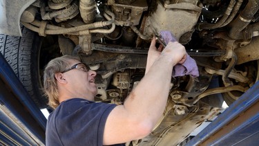 Cliff Alderson, of Alamagordo, N.M., loosens a bolt to let oil pour out during an oil change on a car. Alderson, who is blind, completed the two-year auto mechanic program at Dona Ana Community College. He earned his degree by listening and learning to feel his way around the vehicle.