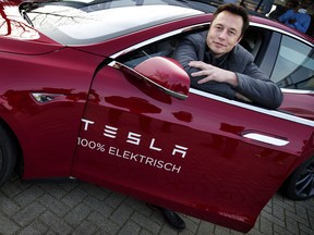 Elon Musk, co-founder and CEO of American electric vehicle manufacturer Tesla Motors, poses with a Tesla