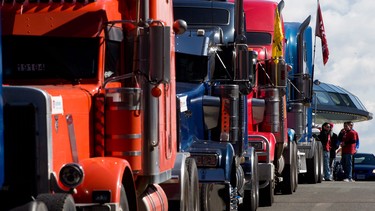 Striking container truck drivers stand by after parking their trucks downtown during a rally in Vancouver.