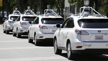 A row of Google self-driving cars are shown outside the Computer History Museum in Mountain View, Calif.