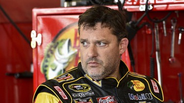 In this Friday, Aug. 8, 2014 photograph, Tony Stewart stands in the garage area after a practice session for Sunday's NASCAR Sprint Cup Series auto race at Watkins Glen International, in Watkins Glen N.Y.  Stewart struck and killed Kevin Ward Jr., 20, a sprint car driver who had climbed from his car and was on the track trying to confront Stewart during a race at Canandaigua Motorsports Park in upstate New York on Saturday night. Ontario County Sheriff Philip Povero said his department's investigation is not criminal and that Stewart was "fully cooperative" and appeared "very upset" over what had happened.