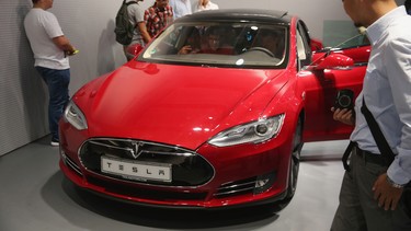 Shoppers look at a Tesla Model S.