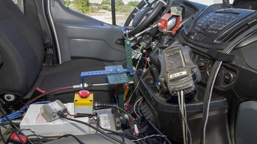 A robotic autonomous device is seen fixed to the controls of a Ford Transit van in Romeo, Mich., in 2013. A number of automakers are planning self-driving vehicles, including Daimler.