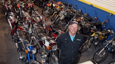 In this photo from 2011,  Don Fergin 
stands with some of the 50 motorcycles, including a 1964 white Honda Dream, from Ray Lamb's amazing collection.