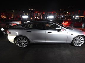 Drivers test the new Tesla 'D' model which is a faster and all-wheel-drive version of the Model S electric sedan at the Hawthorne Airport in Los Angeles on October 9, 2014.