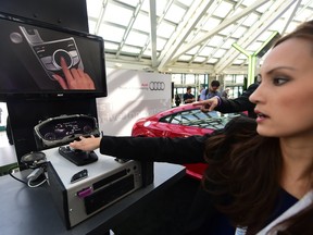 An Audi rep gives a demonstration of the virtual cockpit system which will come in the 2016 model of the Audi TTS at the Connected Car Expo on the opening press and trade day at the L.A. Auto Show in Los Angeles, California on Nov. 18, 2014.