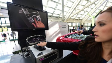 An Audi rep gives a demonstration of the virtual cockpit system which will come in the 2016 model of the Audi TTS at the Connected Car Expo on the opening press and trade day at the L.A. Auto Show in Los Angeles, California on Nov. 18, 2014.