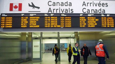 Air Canada workers walk at Pearson International Airport in Toronto on March 8, 2012.