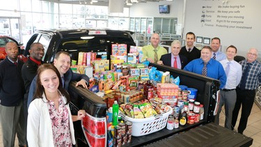 Staff at Advantage Ford in Calgary pose with food collected for the Calgary Interfaith Food Bank.