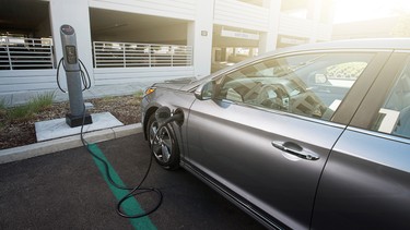 A Hyundai Sonata Plug-in Hybrid (PHEV) at a charging station outlet