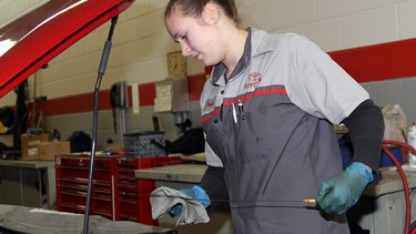 Apprentice mechanic Taylor Giesbrecht, 22 — here checking a vehicle’s oil level — loves working with cars and machinery.