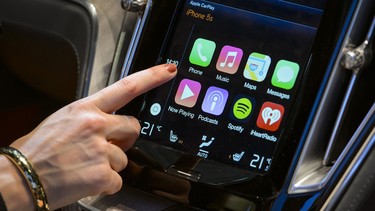 A visitor presses Apple's new CarPlay touch-screen commands inside the Volvo Estate concept car displayed during the press day of the Geneva Motor Show in Geneva, on March 4, 2014.
