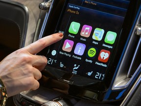 A visitor presses Apple's new CarPlay touch-screen commands inside the Volvo Estate concept car displayed during the press day of the Geneva Motor Show in Geneva, on March 4, 2014.