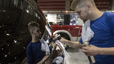 Eric Wigston, a detail rep with Penske Vehicle Services, shines up a 2015 Chrysler Town and Country S in preparation for the 2015 International Auto and Truck Show at the BMO Centre in Calgary, on March 10, 2015.