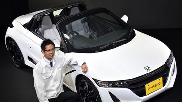 Honda engineer Ryo Mukumoto displays the company's new compact sports car "S660" at the Honda's headquarters in Tokyo.