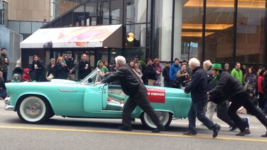 Columnist Alyn Edwards, centre, Red Robinson, Rich Elwood and spectators push Natalie Speckmaier’s 1955 Ford Thunderbird to the finish line during Vancouver’s recent St. Patrick’s Day Parade.