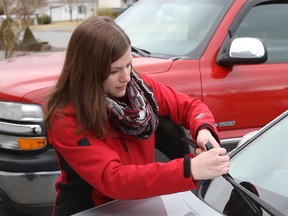 A representative with Canadian Tire installs new wiper blades on a resident's vehicle.