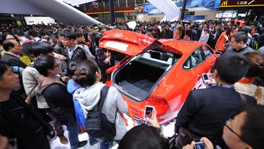 Visitors look at an Audi S7 on the opening day of the Shanghai auto show on April 21, 2013.