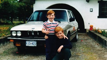 Brendan McAleer, kneeling, poses with younger brother Kieran in front of their father's BMW 535i.