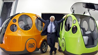 Guy Negre, head of MDI (Motor development International) company, stands between "Airpod One" prototypes of non-polluting minicars driven with a joystick, activated by compressed air in this October 9, 2008 file photo in Nice, southern France.