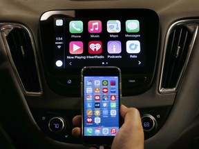 An iPhone is connected to a 2016 Chevrolet Malibu equipped with Apple CarPlay apps.