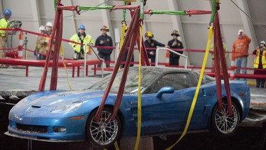 One of eight Chevrolet Corvettes is removed from a sinkhole in the Skydome at the National Corvette Museum, Monday, March. 3, 2014, in Bowling Green, Ky.