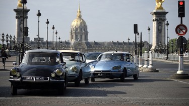 People in Citroen DS drive in front of Les Invalides in Paris on May 24, 2015 as the legendary French car celebrates its 60th anniversary.