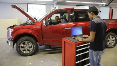 In this photo taken Thursday, Aug. 13, 2015, Nitin Bandaru, right, works on a hackathon project at the Ford Motor Company Research and Innovation Center in Palo Alto, Calif. The convergence of cars and technology is blurring the traditional geographical boundaries of both industries. Silicon Valley is dotted with research labs opened by automakers and suppliers, who are racing to develop high-tech infotainment systems and autonomous cars.