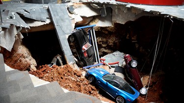 This Feb. 12, 2014, file photo, shows a sinkhole that opened up swallowing eight classic and historic Corvettes at the National Corvette Museum in Bowling Green, Ky. Work ended recently to fill in the pit that consumed eight prized sports cars, and the repaired exhibit area has become a magnet for visitors, with the dirt-caked remains of the mangled cars being the stars.