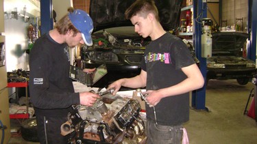 Calgary's Worth Auto trains youth in the world of automotive mechanics. Here, Chris Doty (left) and James Johnson are rebuilding a supercharged V6 engine for a 2000 Pontiac Grand Prix.