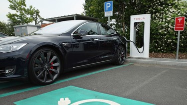 A Tesla electric-powered sedan stands at a Tesla charging station at a highway rest-stop along the A7 highway on June 11, 2015 near Rieden, Germany. Wireless charging highways and roads, if they were ever to be built on a larger scale, could help electric cars eventually take over traditional gas-powered vehicles.