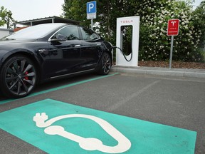 A Tesla electric-powered sedan stands at a Tesla charging station at a highway rest-stop along the A7 highway on June 11, 2015 near Rieden, Germany.