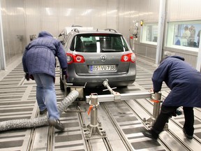 Two Volkswagen employees push a VW Passat into the new "Cold and Climate" centre at the Volkswagen plant in Wolfsburg. The German automaker admitted to rigging its diesel vehicles to pass U.S. emissions testing.