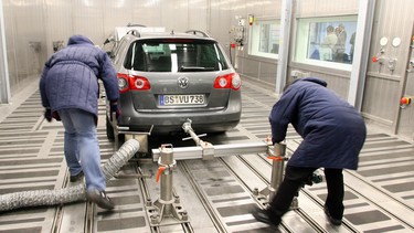 Two Volkswagen employees push a VW Passat into the new "Cold and Climate" centre at the Volkswagen plant in Wolfsburg. The German automaker admitted to rigging its diesel vehicles to pass U.S. emissions testing.