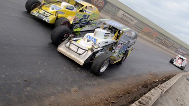 In this Oct. 13, 2013, photo, Billy Dunn (49) of Watertown, N.Y., right foreground, drives through turn four during the Super Dirt Car Series Syracuse 200 auto race at the New York State Fairgrounds in Syracuse, N.Y. When the checkered flag waves for the final time, on Sunday, Oct. 11, 2015,  it will be goodbye to one of only six mile-long dirt tracks remaining in the United States, according to local race historian Gary Spaid.