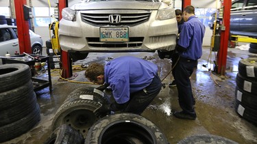 Staff switch a vehicle over to winter tires at the KAL Tire location on Pembina Highway in Winnipeg, Man., on Sat., Nov. 21, 2015.